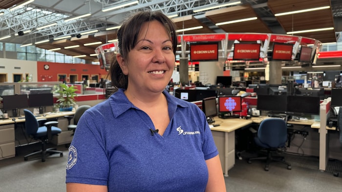 Une femme portant le polo de la Société de sauvetage de la Colombie-Britannique et du Yukon dans les locaux de CBC/Radio-Canada Vancouver.