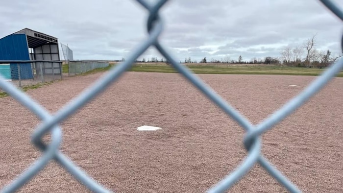 Un terrain de baseball, vue à travers la clôture.