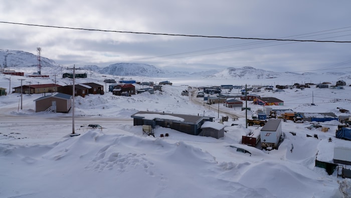 Une image de bâtiments recouverts par la neige au Nunavut.