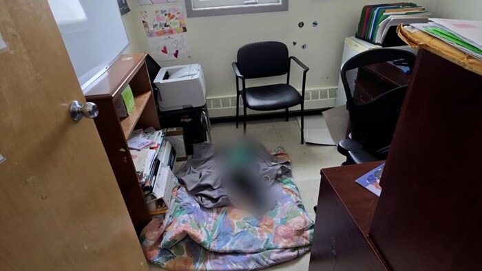Une image d'un enfant embrouillé couché sur le sol d'une petite salle.