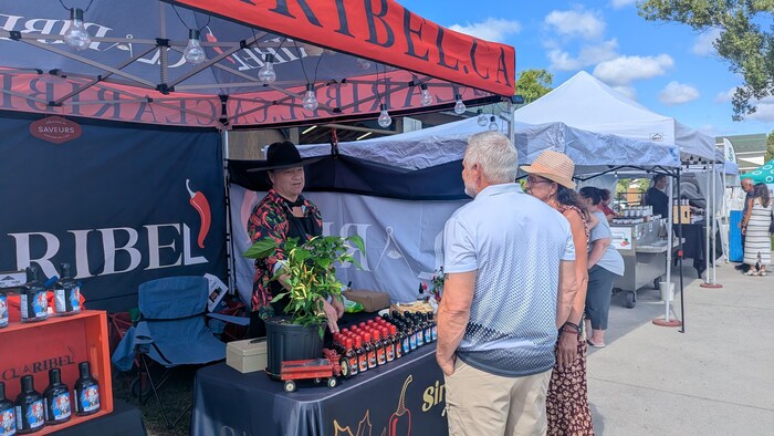 Des visiteurs écoutent le représentant de Claribel leur parler de ses produits.