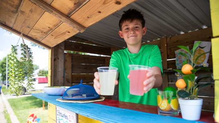 Chrisitian qui tend deux verres de limonade.