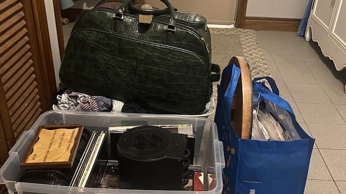 Des sacs et des boites remplies de vêtements de documents importants et de photos.