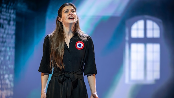 Elle chante sur scène. 