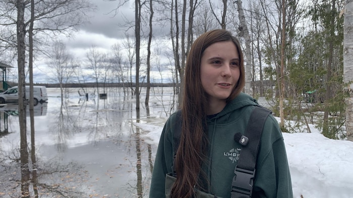 Koralie Fortin porte une salopette pour éviter de mouiller ses vêtements. Le lac Montbeillard a débordé sur son terrain.