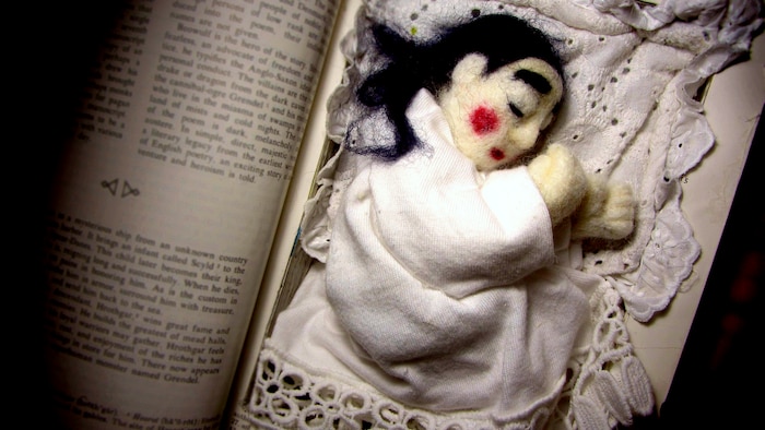 Une marionnette endormie au creux d'un livre.