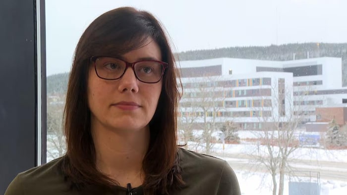 Une jeune femme avec des lunettes rouge nommée Kristi Allan.