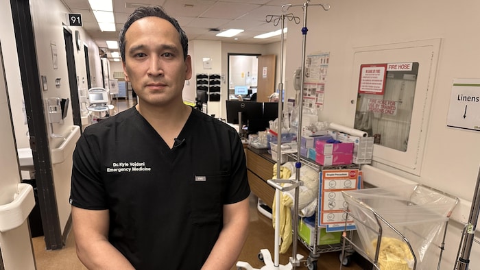 Le médecin pose dans un couloir. 