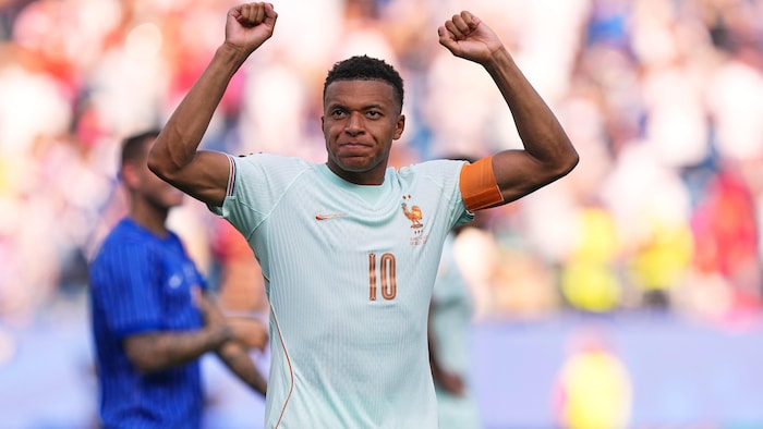 Kylian Mbappe les bras levés.