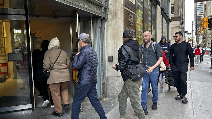 Des gens entrent au magasin La Baie.