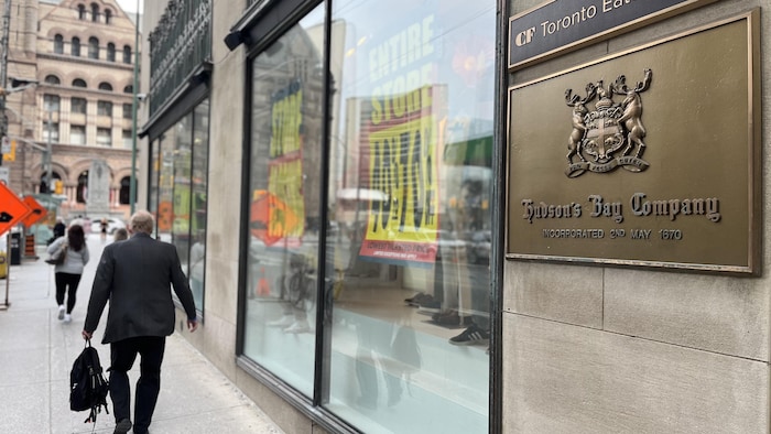 Des passants marchent à coté d'un magasin de la Baie d'Hudson.