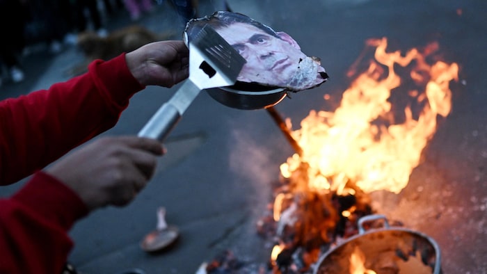 Un manifestant s'apprête à bruler la photo du président Rodrigo Paz.