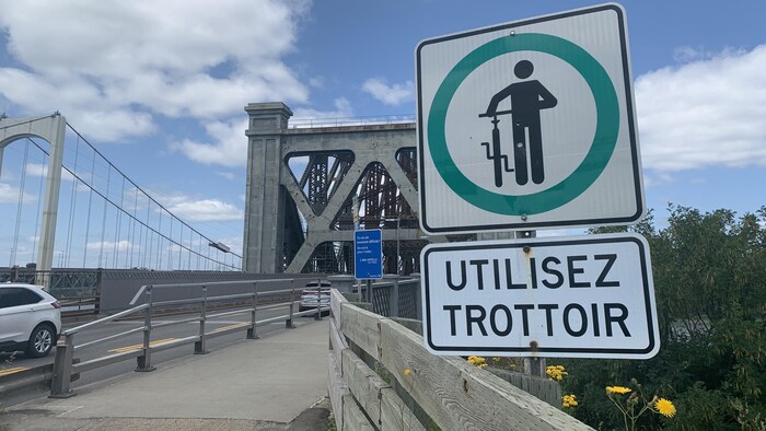 Affiche sur le bord de la piste cyclable, juste avant le pont.