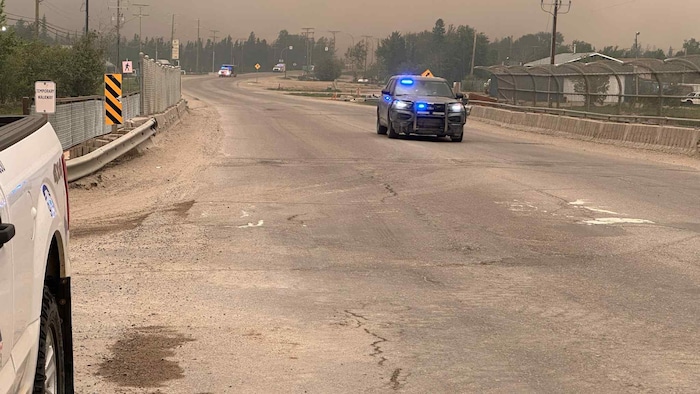 Une voiture de police bloque l'accès à la route.