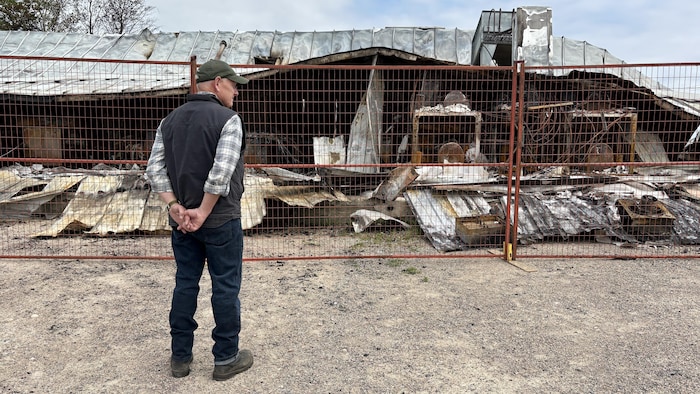Scott Robertson in front of a building destroyed by a rodent forest fire, in Saskatchewan, on June 2, 2025. state emergency lifted saskatchewan after