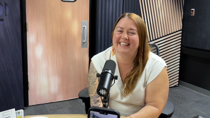 Une femme dans un studio radio pour une entrevue.