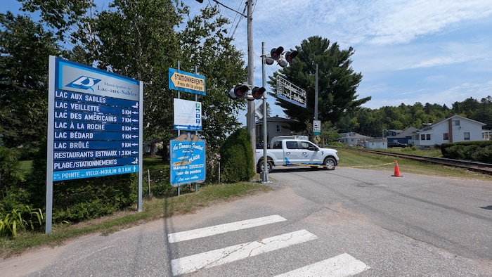 Une affiche de la municipalité de Lac-aux-Sables et une rue barrée.