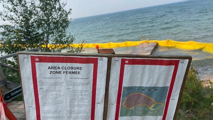 Des panneaux et un rideau de confinement dans le lac.