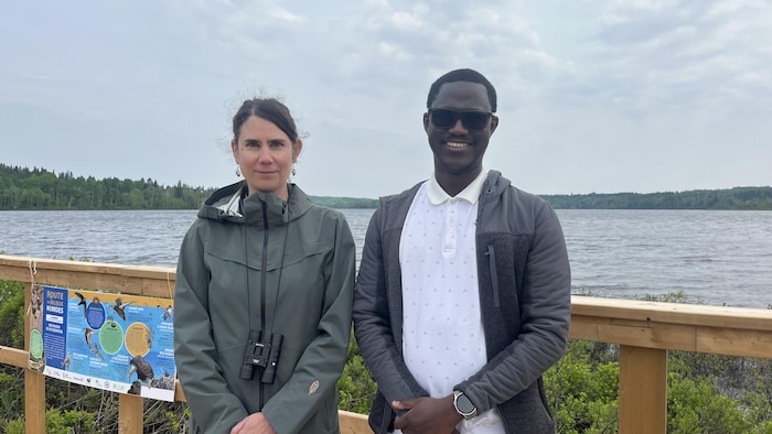 Deux personnes posent devant un lac.