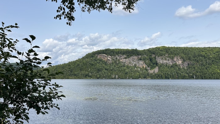 La photo montre un lac avec des falaises au loin. 