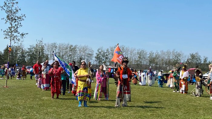 Des membres d'une Première Nation du Manitoba dansant et défilant portant des vêtements colorés. 