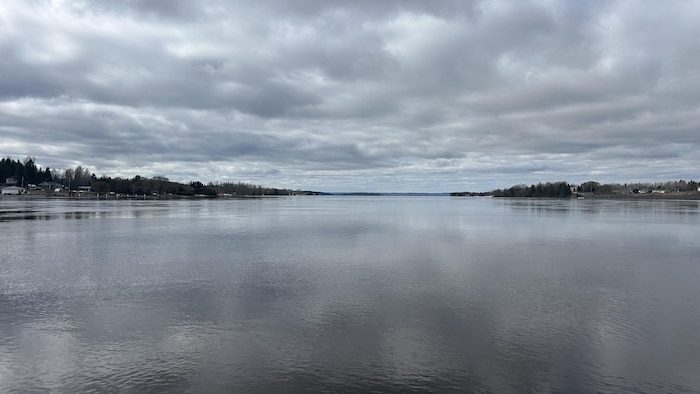 Le lac Témiscamingue, très calme, reflète les nuages dans ciel.