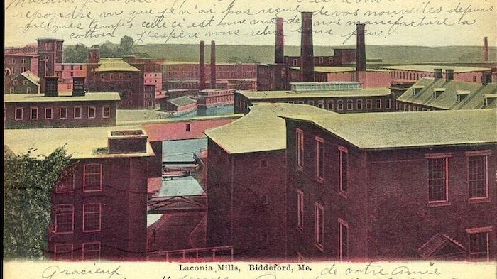 Une carte postale montrant une vieille usine avec des notes écrites en français.
