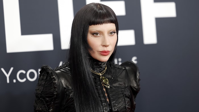 Une femme aux longs cheveux noirs est vêtue de noir.