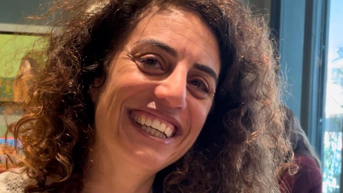 Une femme souriante assise dans un café.