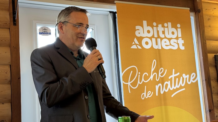 Éric Fournier parle à l'avant de la salle.