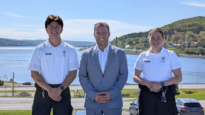 Le maire de Gaspé, Daniel Côté, entouré de deux cadets de la Sûreté du Québec. 