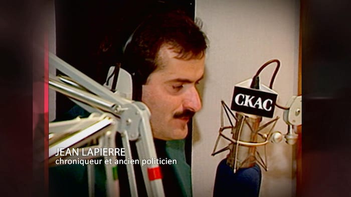 Jean Lapierre, jeune et moustachu, derrière le micro de C K A C.
