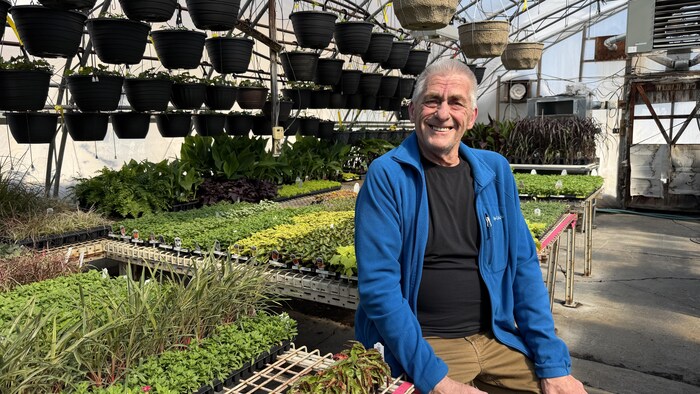 Larry Aiken pose pour la photo à l’intérieur de sa pépinière.