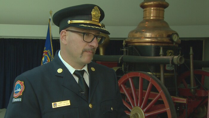 Larry Cocco se tient debout en uniforme de chef de pompier.