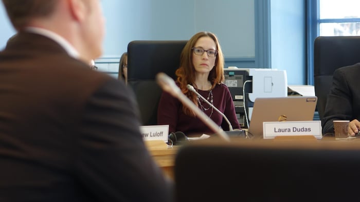 Laura Dudas around a table at the Ottawa municipal council.