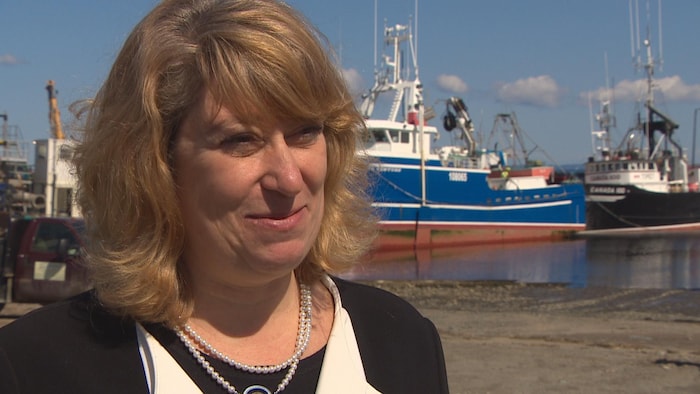 Laurel Broten sur un quai devant des bateaux.