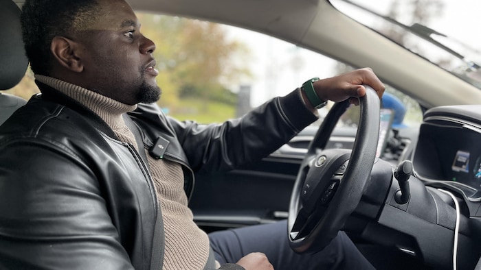Laurent Nzau à bord de sa voiture.