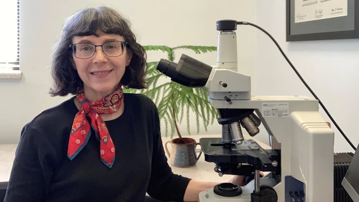 La Dre Geldenhuys assise devant un microscope.