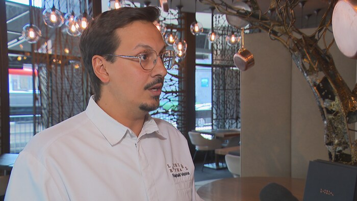 Il est en entrevue dans son restaurant.