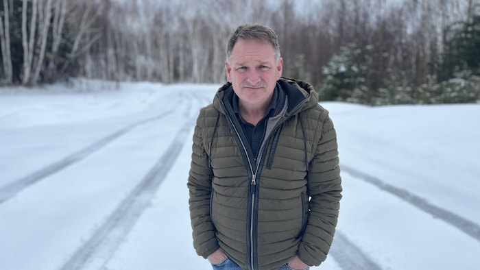 Un homme devant une forêt. 