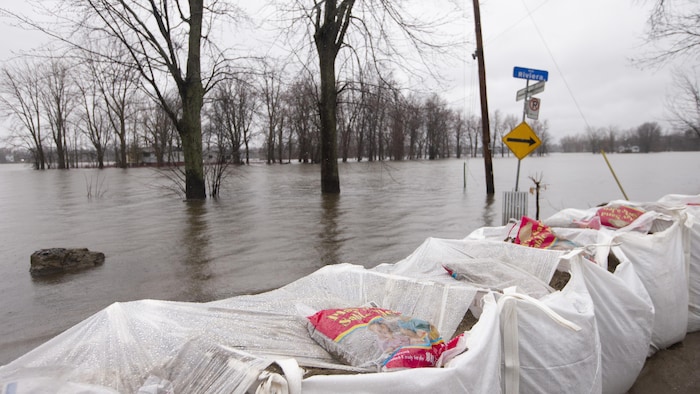 Des sacs de sable ont été installés le long de la rue Riviera, à Laval, tandis que le niveau de la rivière des Mille Îles augmente.