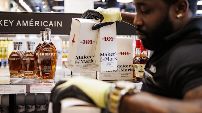 Le personnel d'une succursale de la Régie des alcools de l'Ontario à Toronto retire les vins et spiritueux américains des rayons.