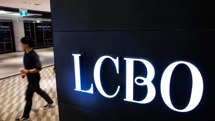 Un homme passe à côté d'une enseigne de la LCBO.