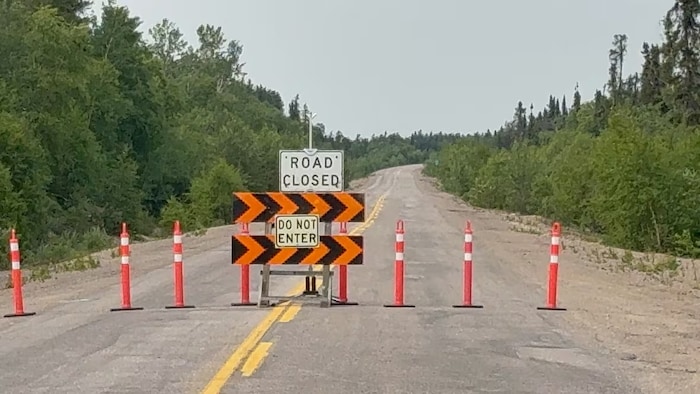 Un panneau annonçant une route fermée et des pylônes bloquent l'accès routier à Leaf Rapids