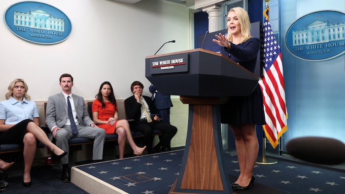 Karoline Leavitt, devant des gens qui la regardent, à la tribune de la presse de la Maison-Blanche.