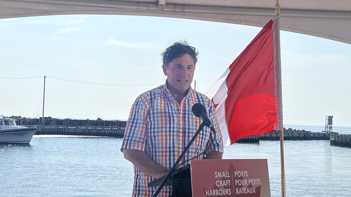 Dominic LeBlanc donne une conférence de presse sur un quai.