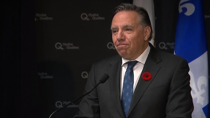 François Legault parle devant un micro.