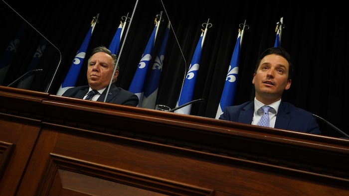 François Legault et Simon Jolin-Barrette devant un micro.