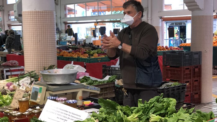 Un producteur maraîcher devant son étal de légumes