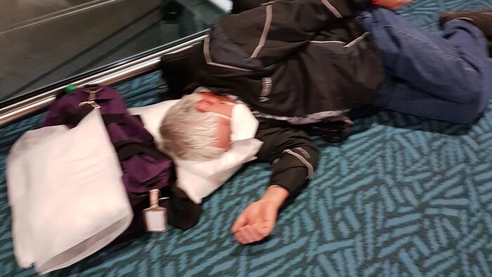 Nakahiga si Frank Michel sa sahig ng paliparan ng Vancouver.